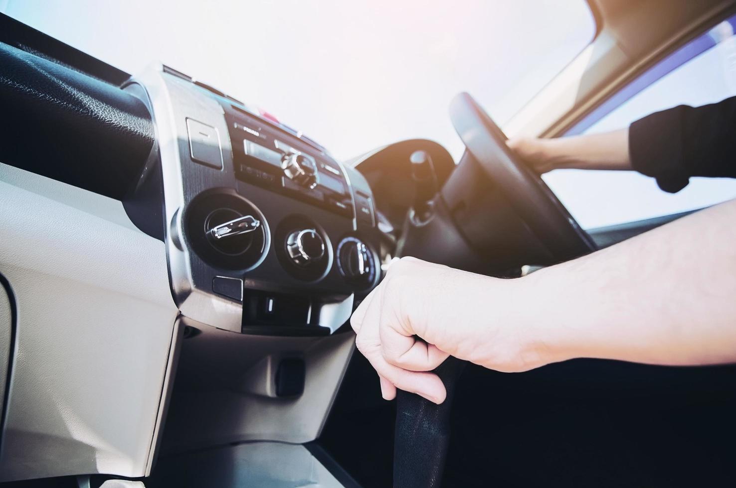 Man driving car holding automatic gear shift transmission control - car driving concept photo