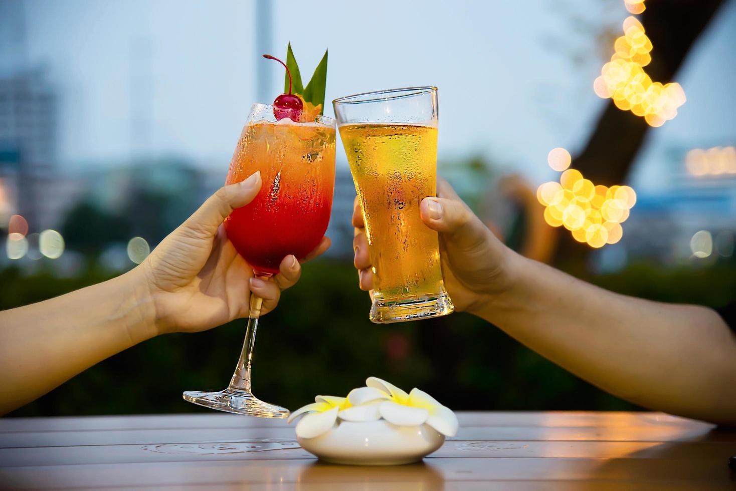 celebración de pareja en el restaurante con cerveza de refresco y mai tai o mai thai - gente de estilo de vida feliz con concepto de refresco foto