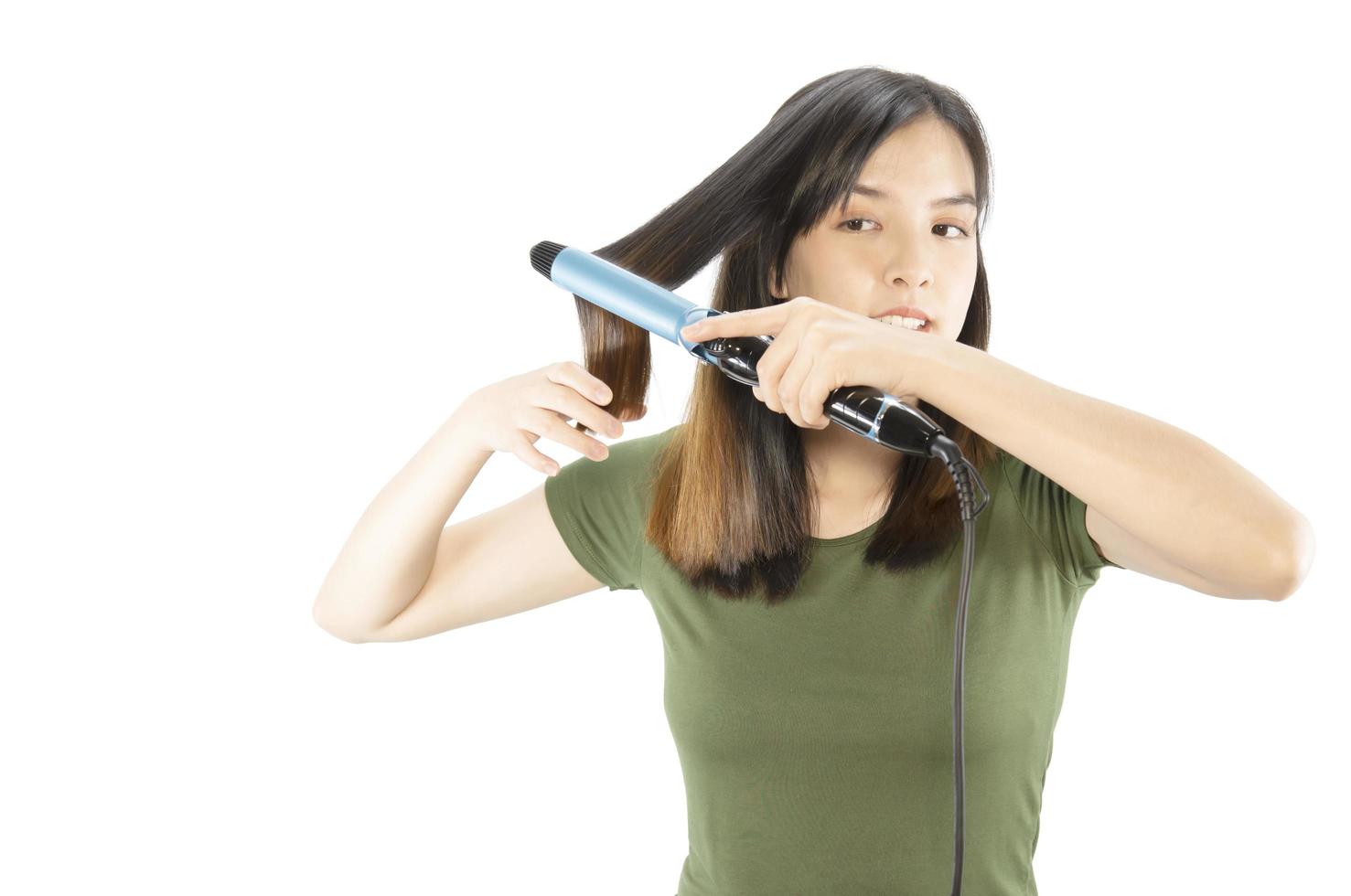 La mujer de belleza cuida su cabello usando una camilla de cabello aislada sobre fondo blanco - personas con concepto de cuidado del cabello foto