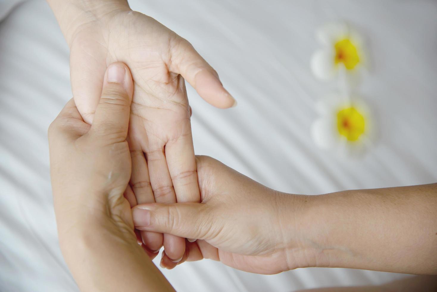 Hand spa massage over clean white bed background - people relax with hand massage service photo