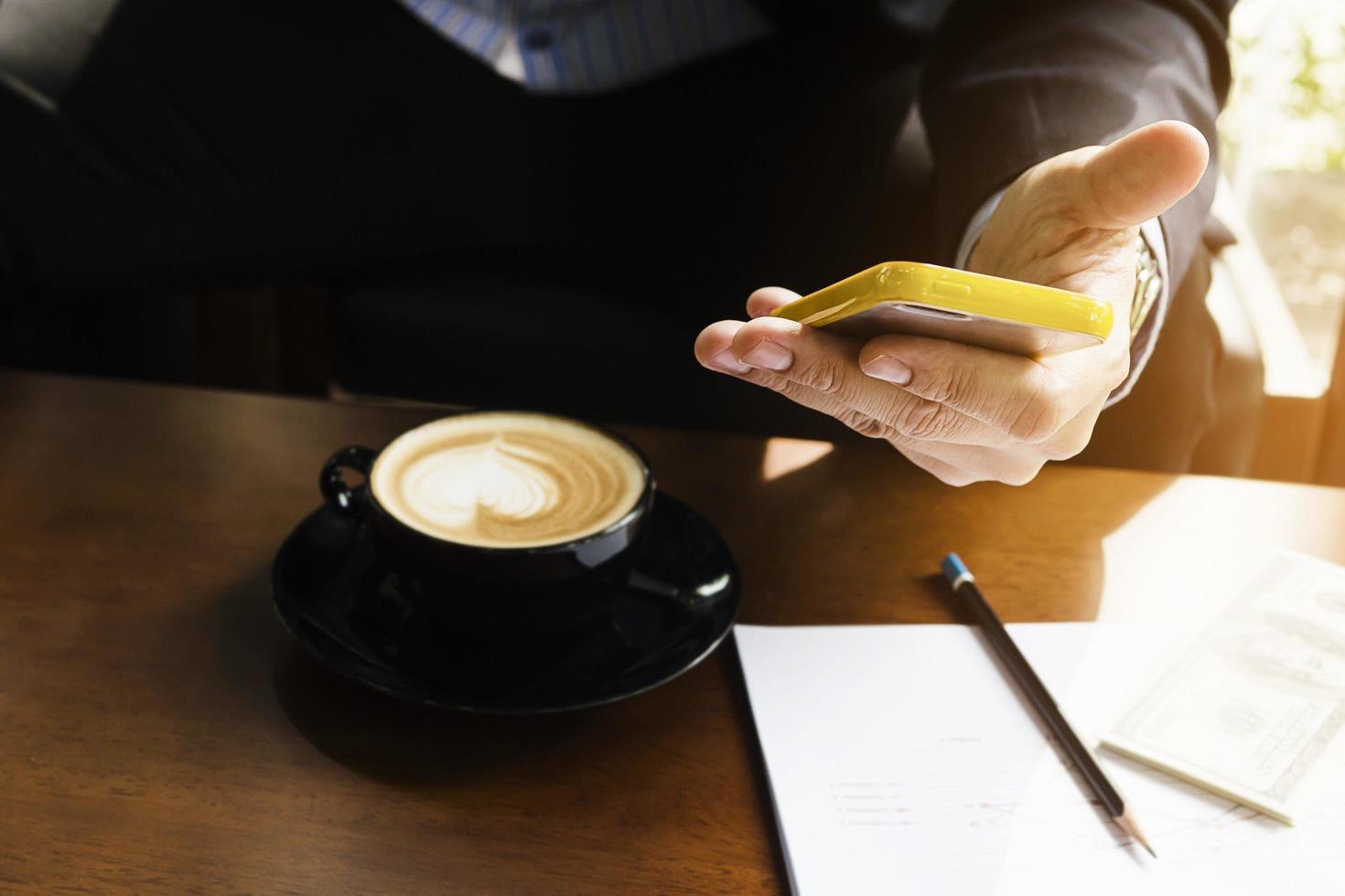 Business man working with mobile in coffee shop photo