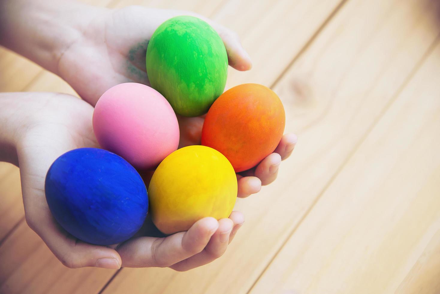 niño mostrando alegremente coloridos huevos de pascua - concepto de celebración de vacaciones de pascua foto