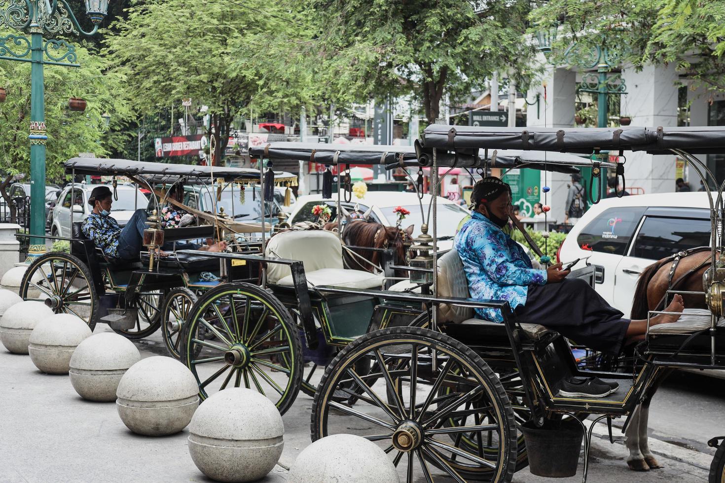 Yogyakarta, Indonesia May 2022 Delman driver waiting for tourist,  stops at Jalan Malioboro. Delman is a traditional transportation use horse. photo