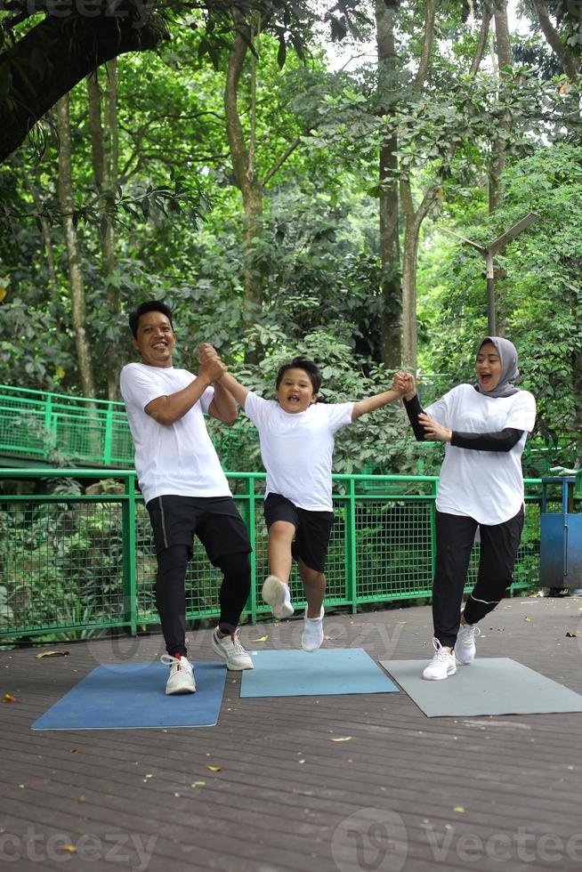 Asian family having fun exercising sport together at the park. photo