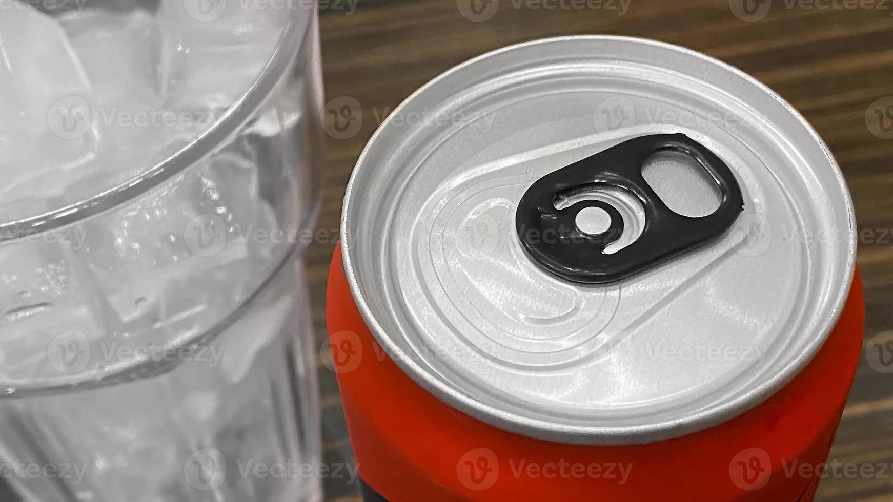 Closed up of Aluminum red soda can with a glass of ice cubes. photo