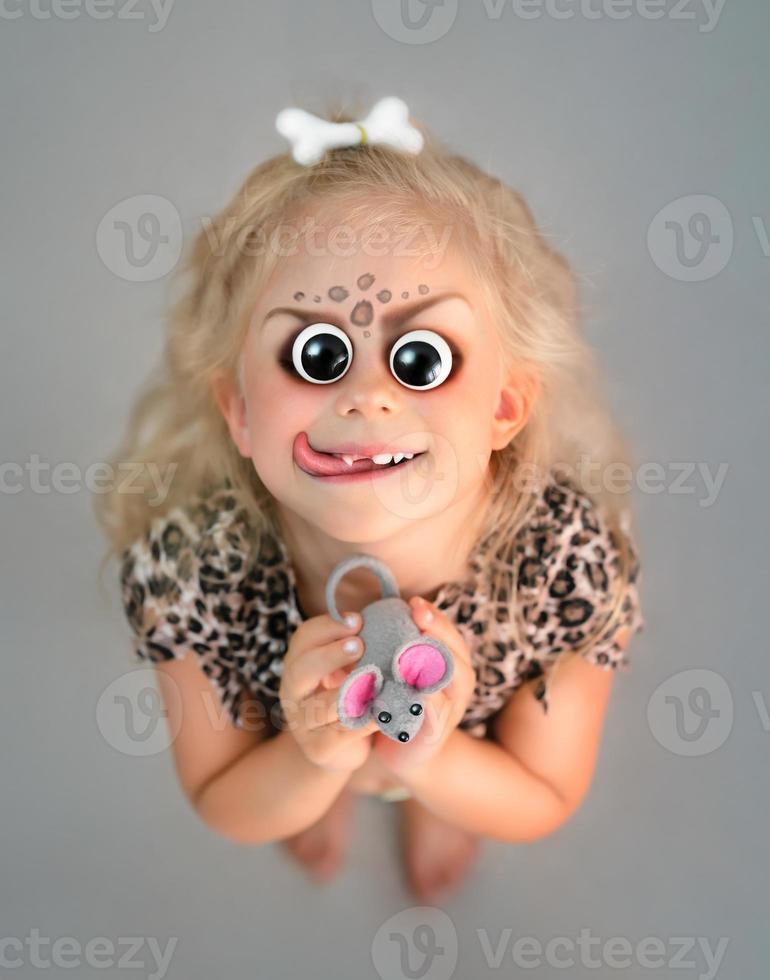 Halloween little girl with scary eyes and toy mouse photo