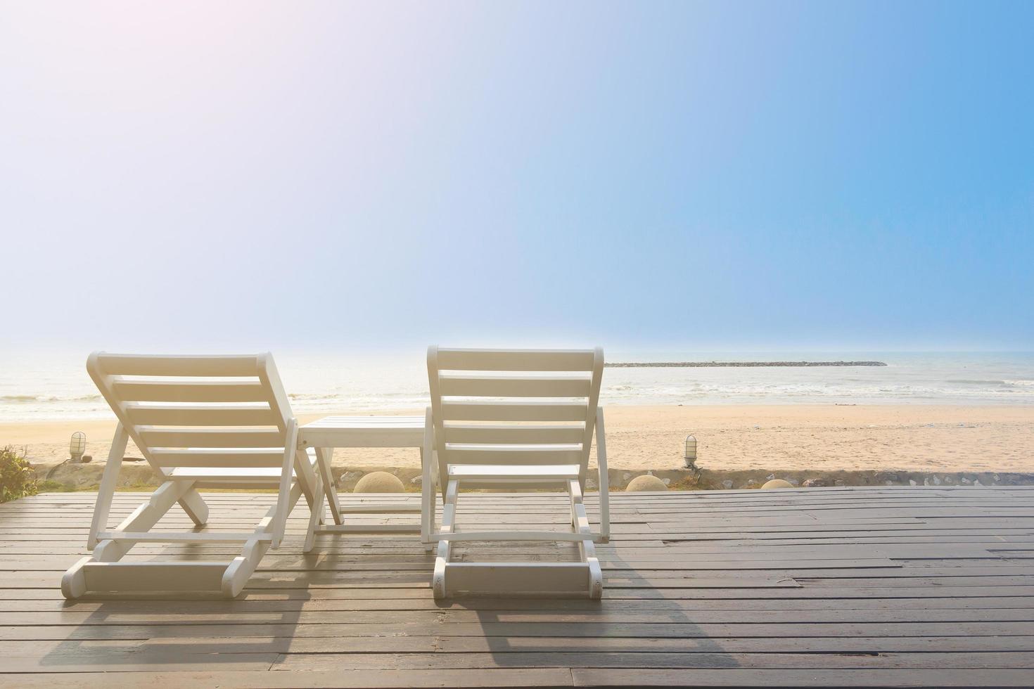 Bench on the beach at yellow sunset photo