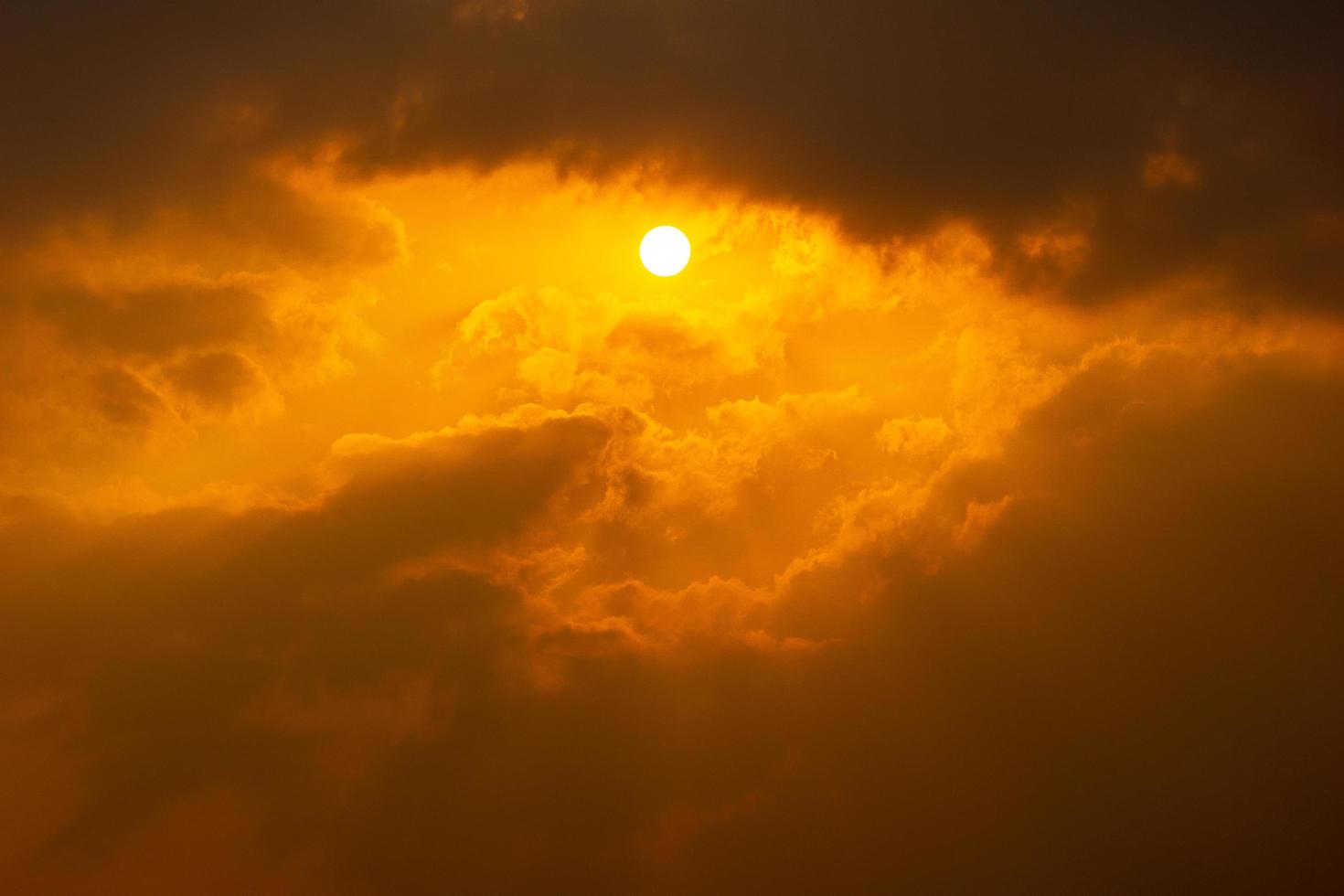 The sun on dramatic cloudy orange sky nature background photo