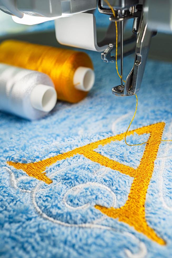 máquina de bordar y diseño de logotipo en toalla foto