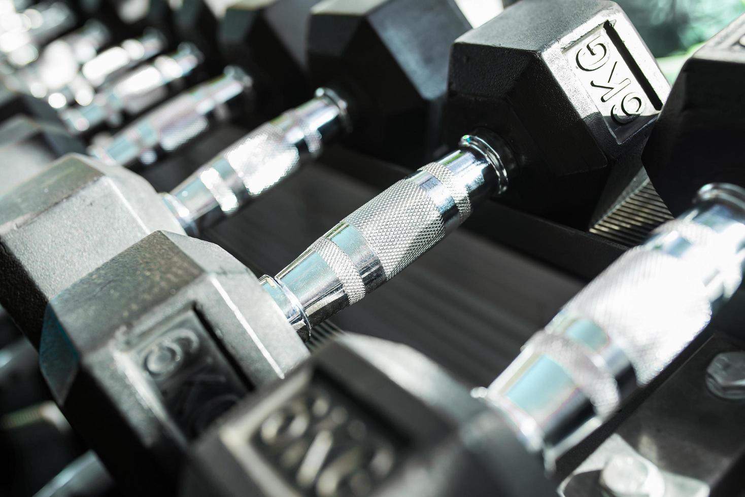 Dumbbells in a rack at the gym. Free weights closeup. photo
