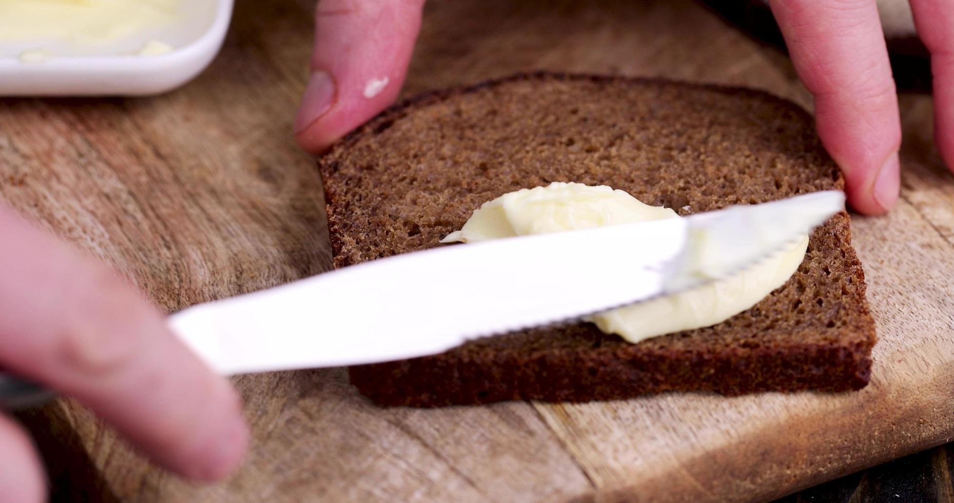 spread butter from milk on black rye bread photo