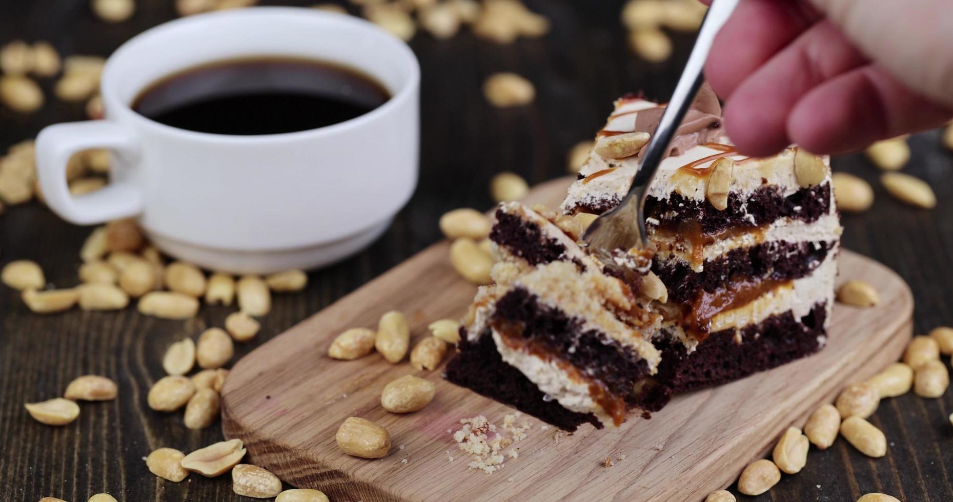 take a piece of cake by piercing it with a dessert fork photo