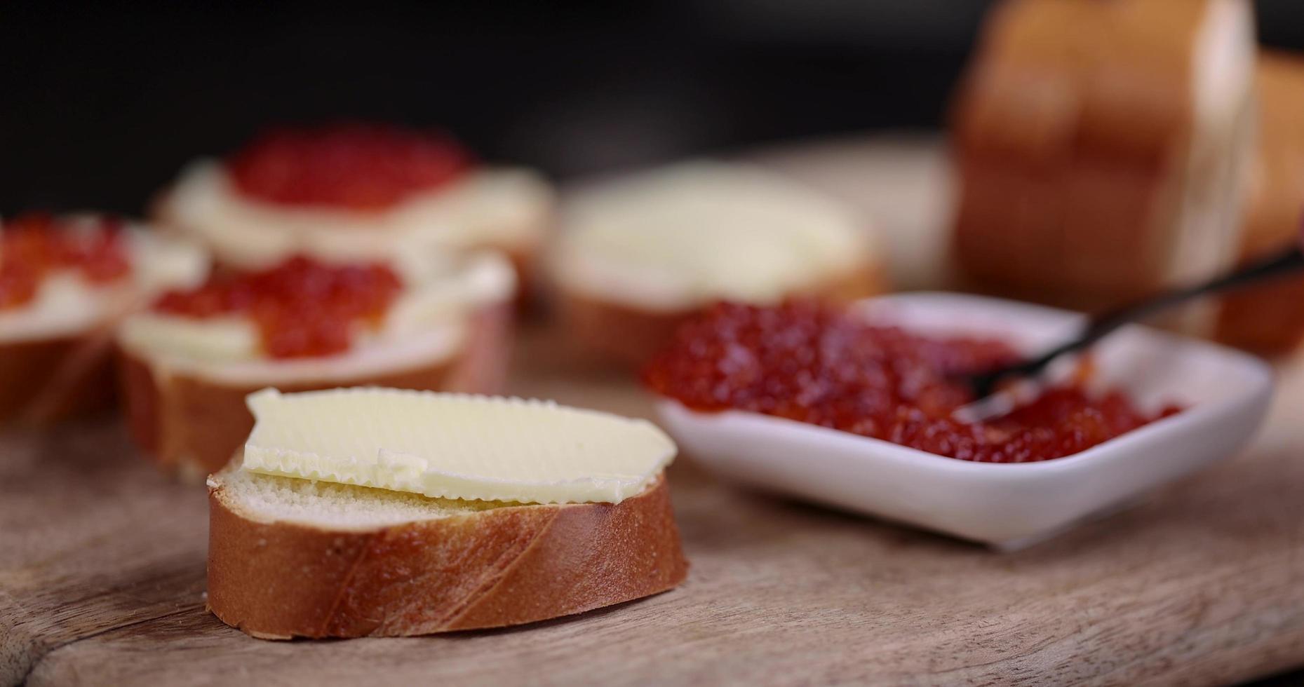 making sandwiches with bread, butter and salmon caviar photo