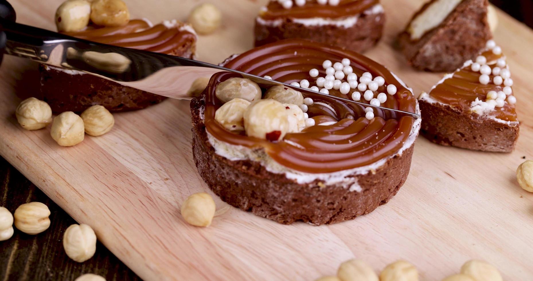cut into pieces of delicious tartlets with buttercream and caramel with nuts photo