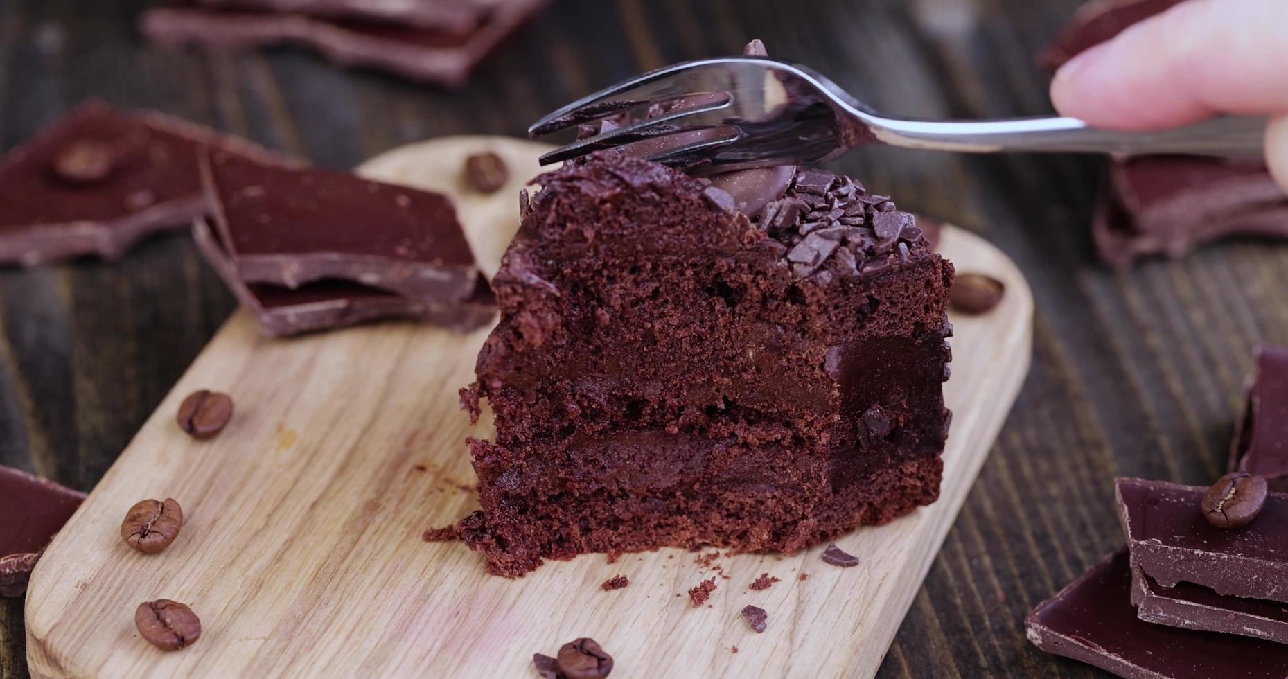 separate a piece of chocolate cake with chocolate filling with a fork photo