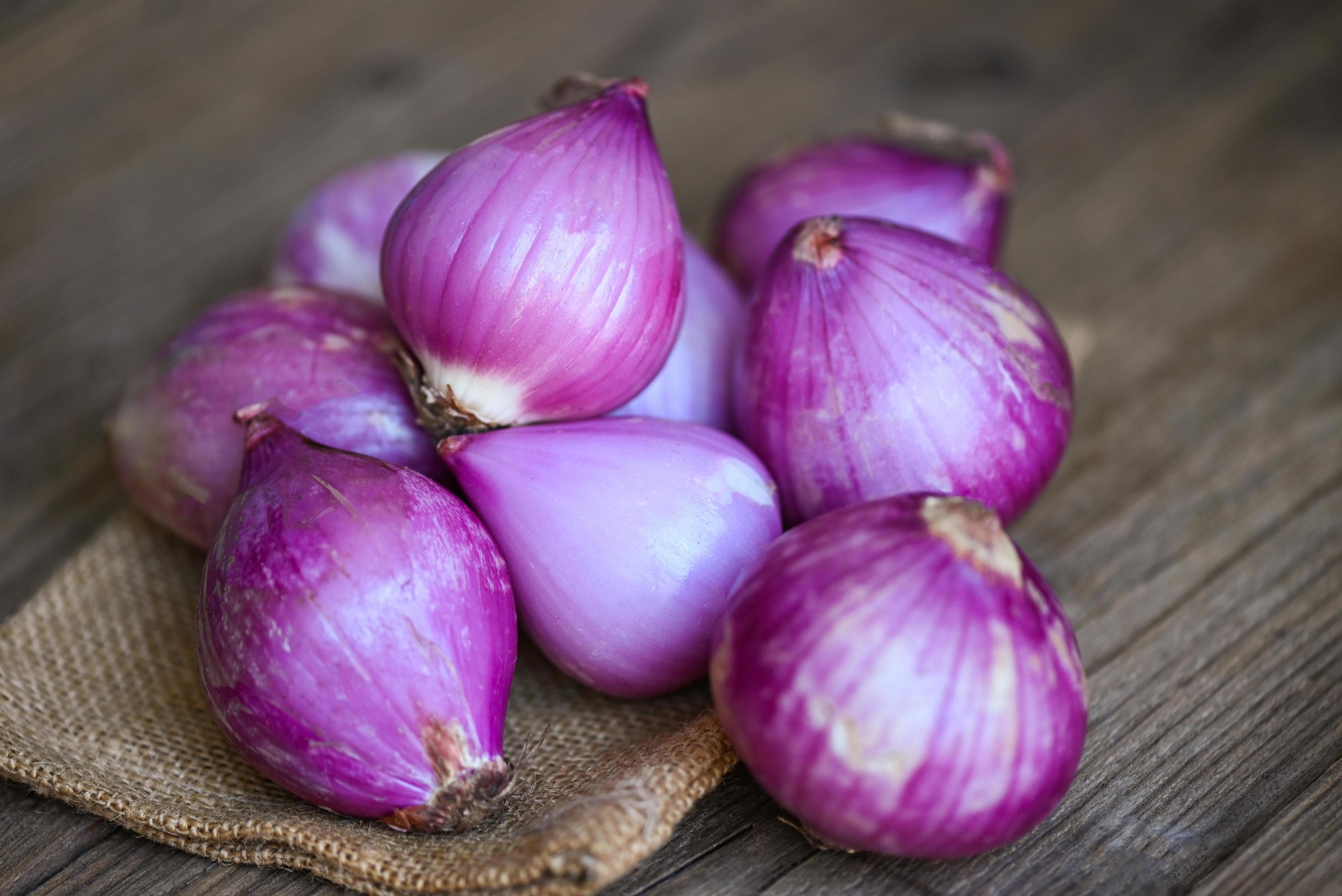 Shallots or red onion, purple shallots on wooden background , fresh shallot  for medicinal products or herbs and spices Thai food made from this raw  shallot 10238227 Stock Photo at Vecteezy