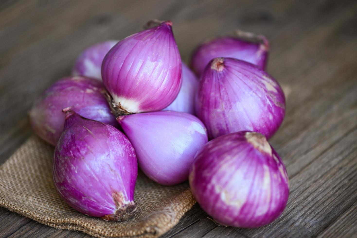 Shallots or red onion, purple shallots on wooden background , fresh shallot for medicinal products or herbs and spices Thai food made from this raw shallot photo