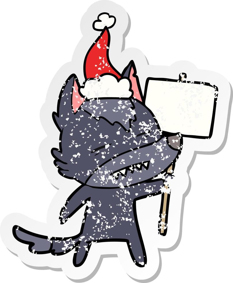 distressed sticker cartoon of a wolf with sign post showing teeth wearing santa hat vector