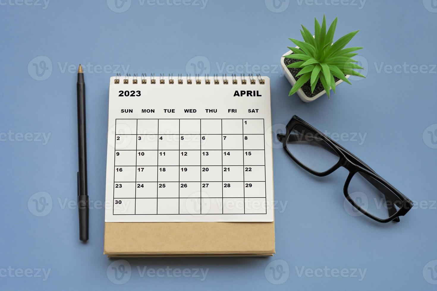 April 2023 desk calendar on blue background. Directly above. photo