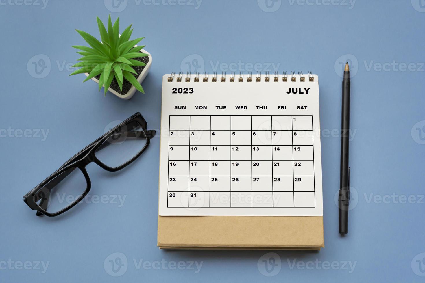 July 2023 desk calendar on blue background. Directly above. photo