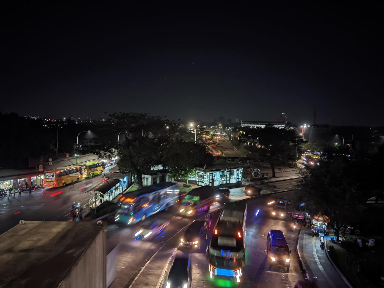 night view of city traffic seen bus stop and several other vehicles photo