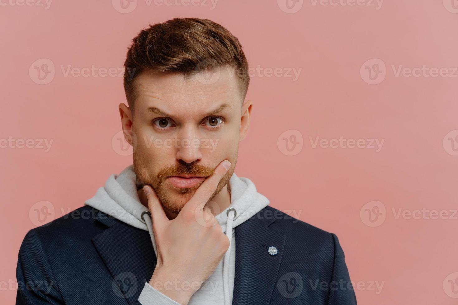 Concerned man holding touching chin and making decision photo