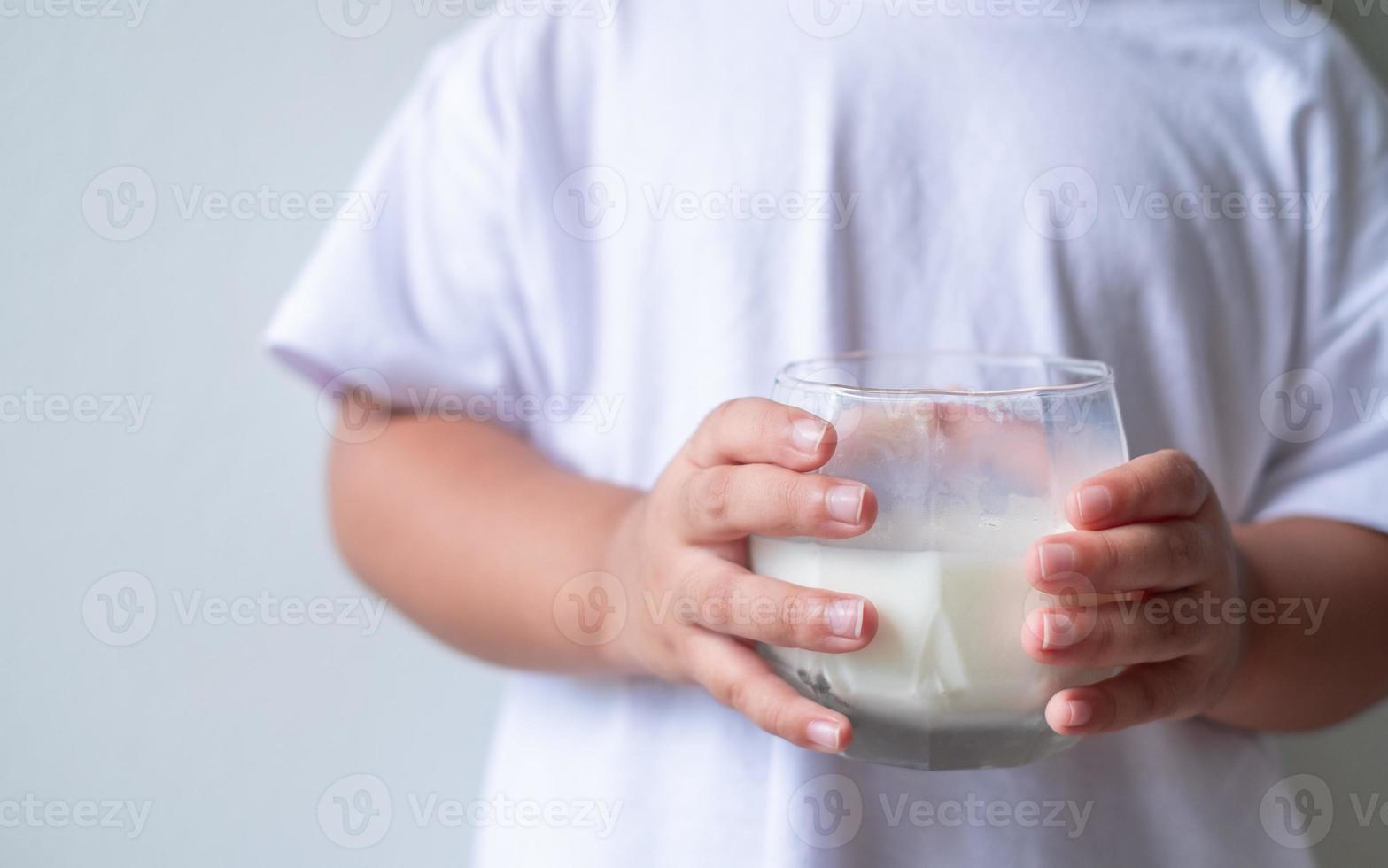 Kid 4-5 years old holding white milk in the glass isolated on white background,Daily life health care Medicine food photo