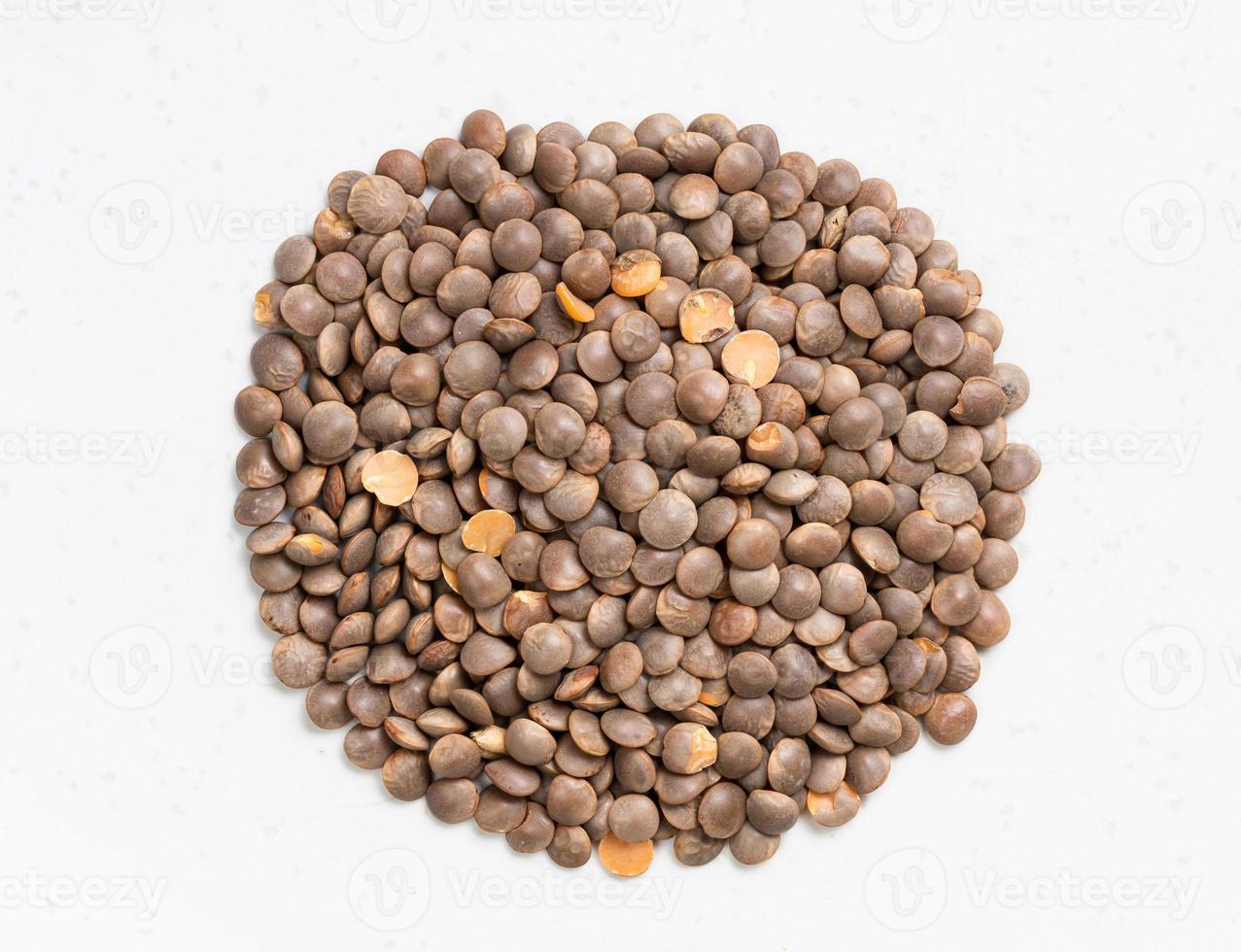 pile of raw brown red lentils close up on gray photo