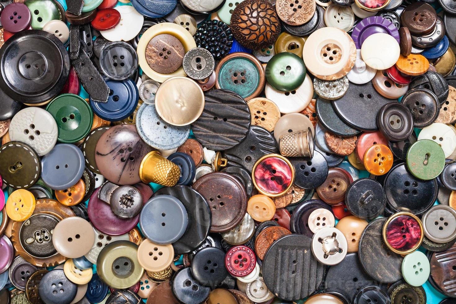 heap of many different buttons close up on blue photo