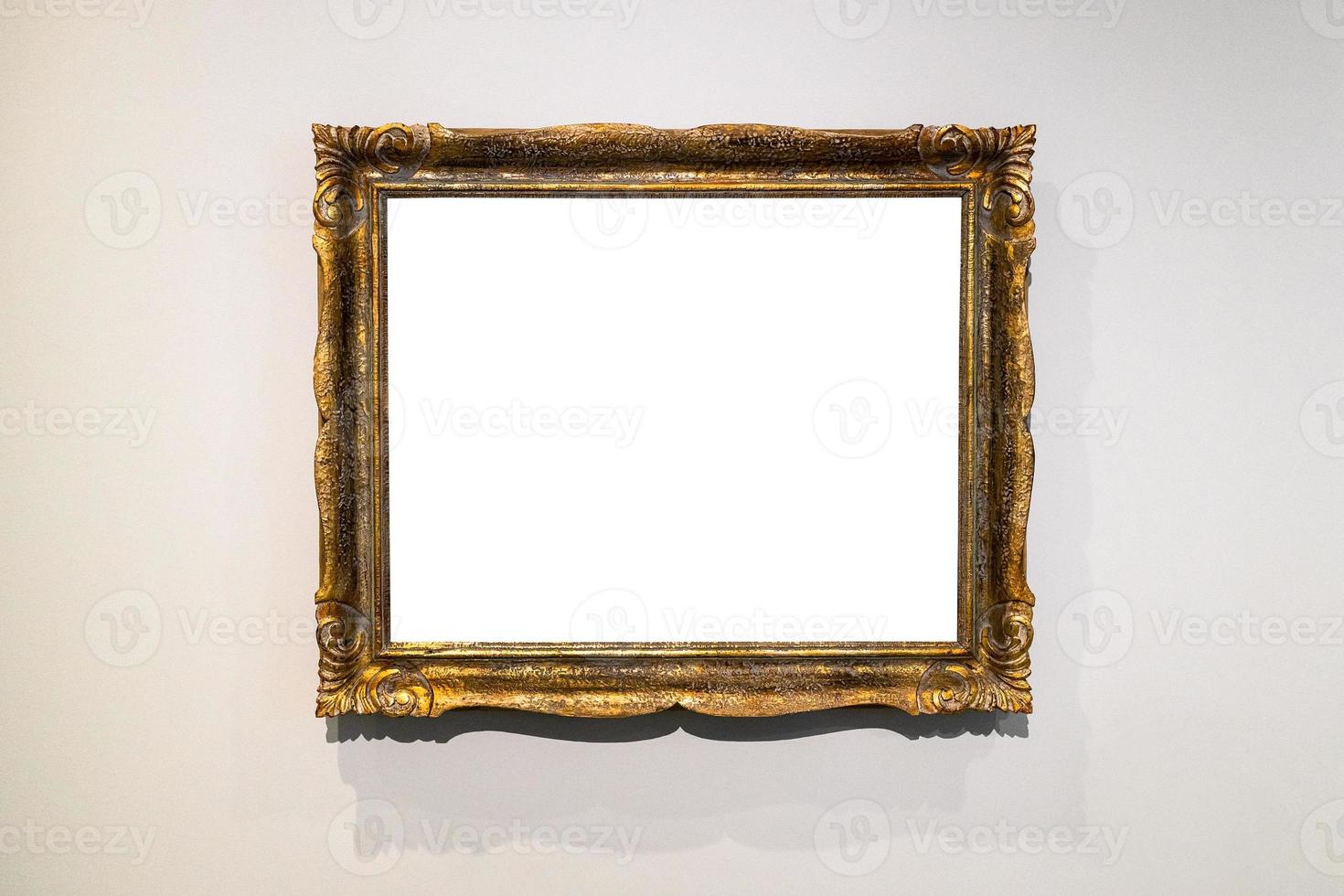 golden ornamental picture frame on gray brown wall photo