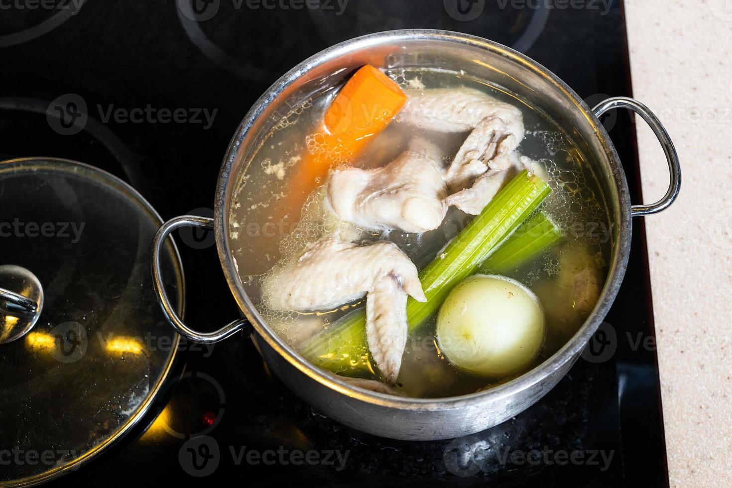 top view of chicken broth in stewpot on stove photo