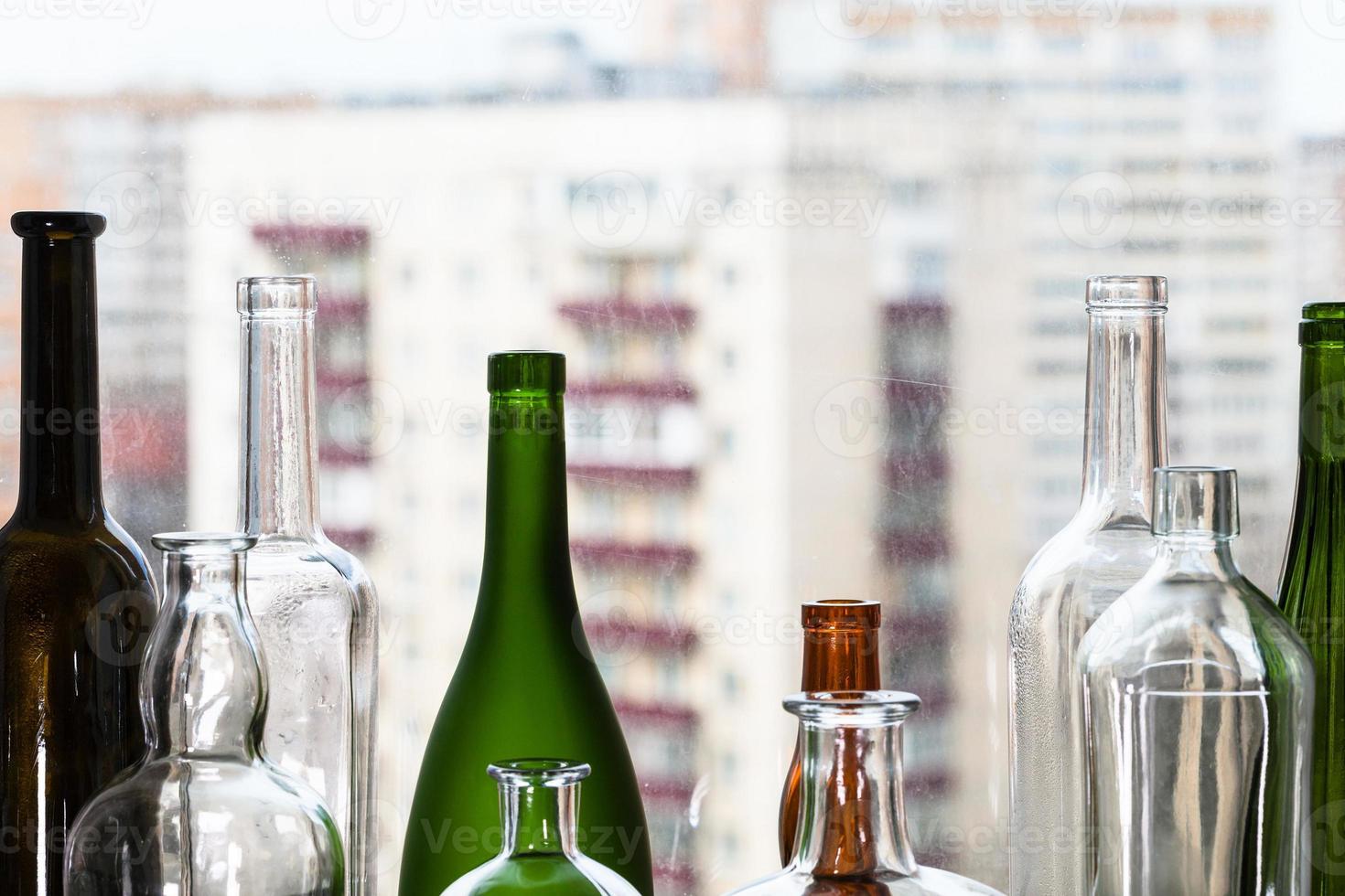 varias botellas vacías y vista de casas de apartamentos foto