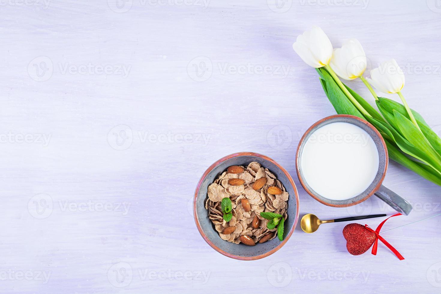 Spelt flakes with milk on breakfast. Light breakfast on Valentine's day with tulips and heart photo