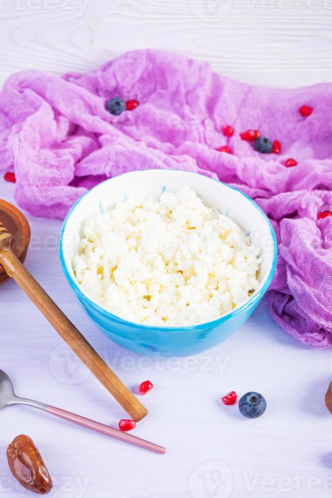 requesón con miel y bayas sobre fondo rosa. desayuno vegetariano ligero foto