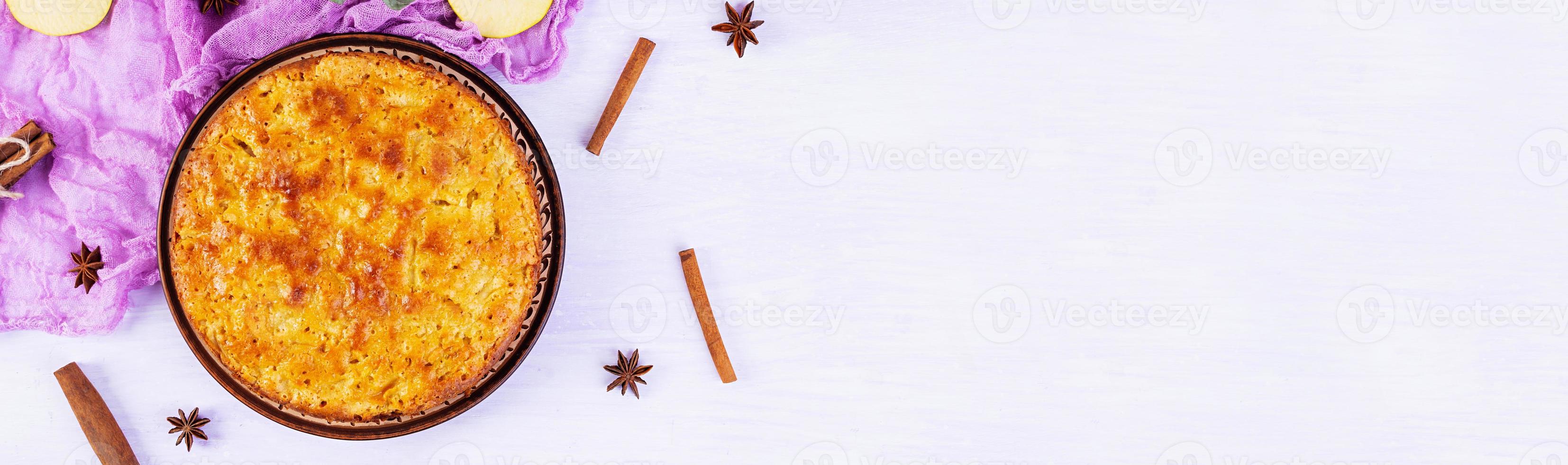 Delicious homemade apple pie on pink background. Apple pie with ingredients, apples and cinnamon. Top view photo