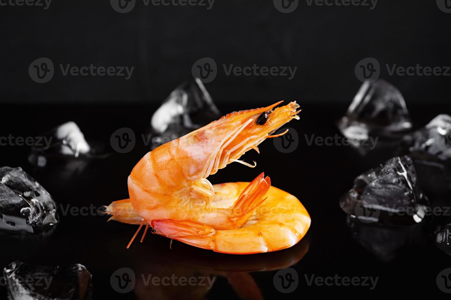 Delicious cooked shrimps isolated on dark background. Boiled prawns photo