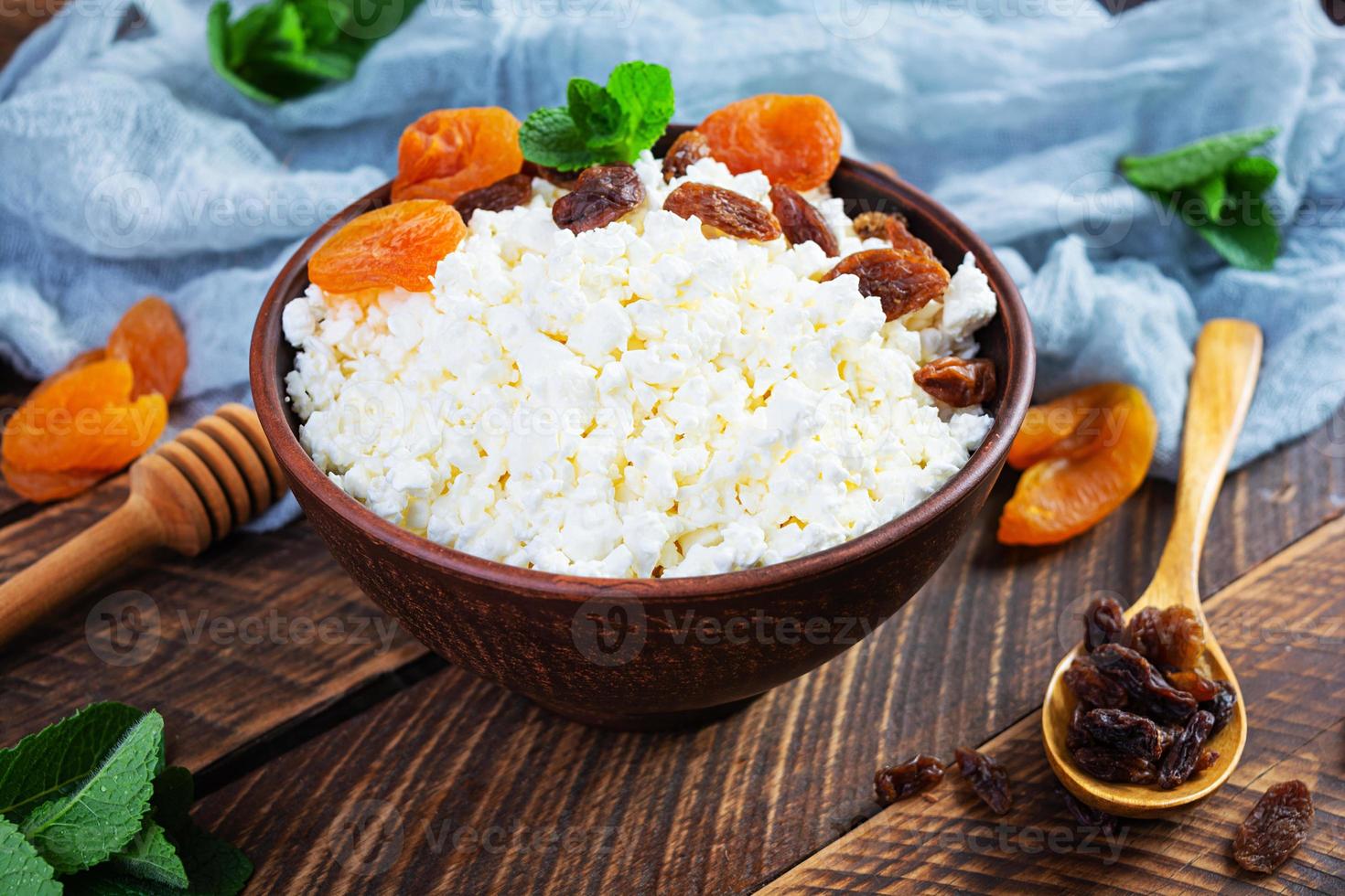 Healthy breakfast cottage cheese with raisins, dried apricots, almond, cashew and mint photo