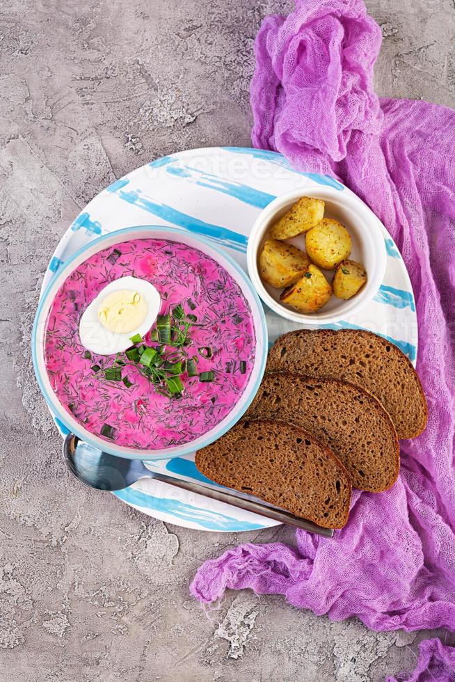 Cold borscht on wooden background. Cold beet soup photo