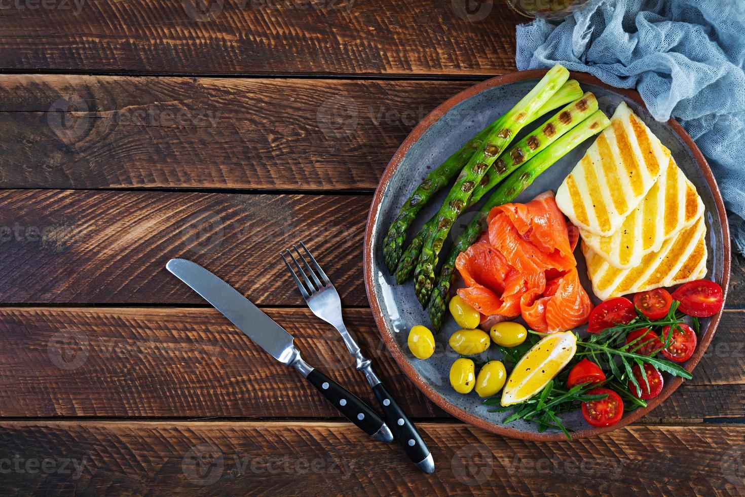 ensalada con espárragos, queso halloumi a la parrilla, filete de salmón, tomates, rúcula y aceitunas verdes. vista superior foto