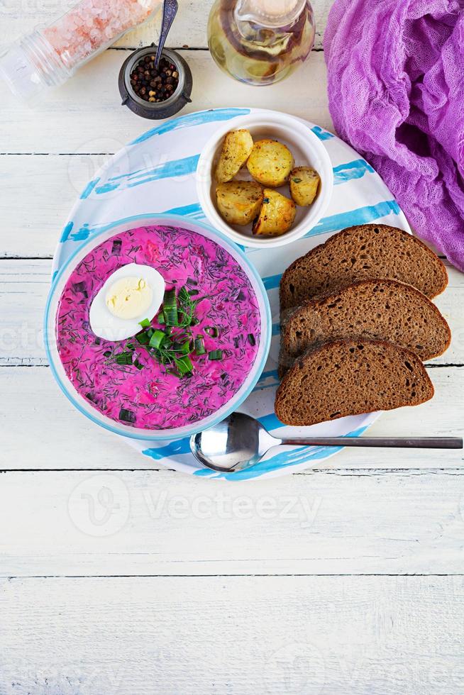 borscht frío sobre fondo blanco de madera. sopa fría de remolacha. vista superior foto