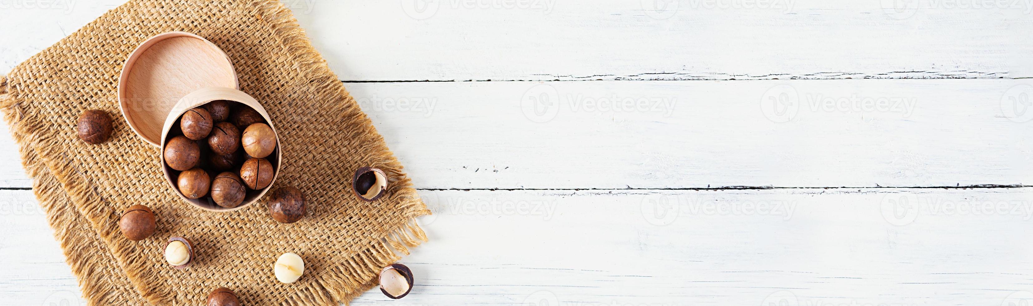 Macadamia nuts in shell on wooden background. Top view photo