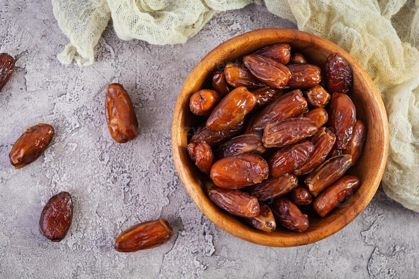 Dried date fruit in bowl on wooden background. Delicious dates fruit