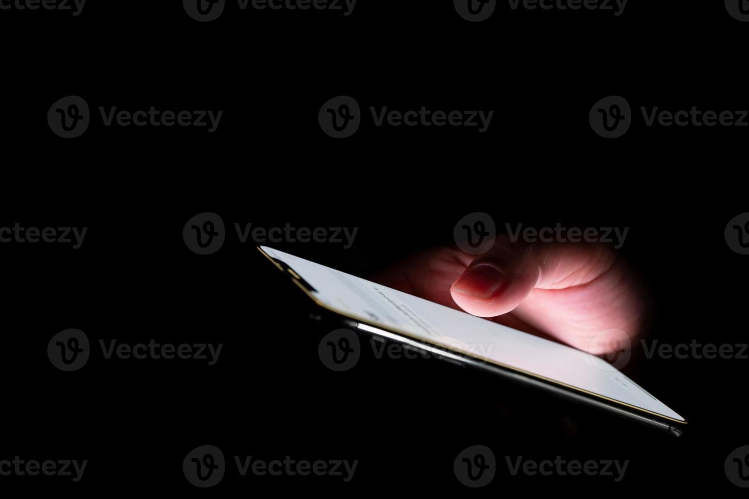 Close-up. female fingers is playing  smartphone on table. Blurred dark background. At night photo