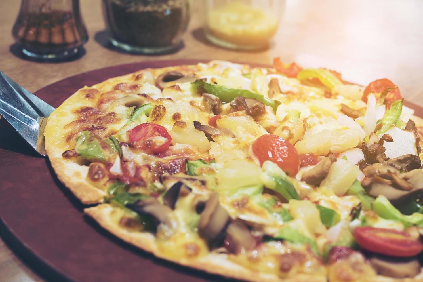 Vintage photo of pizza with colorful vegetable topping ready to be eaten