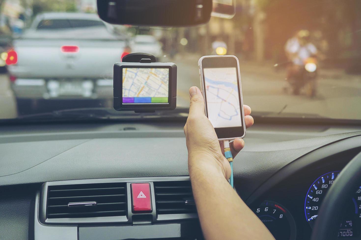 hombre conduciendo un coche usando el navegador y mirando el mapa en el teléfono móvil foto