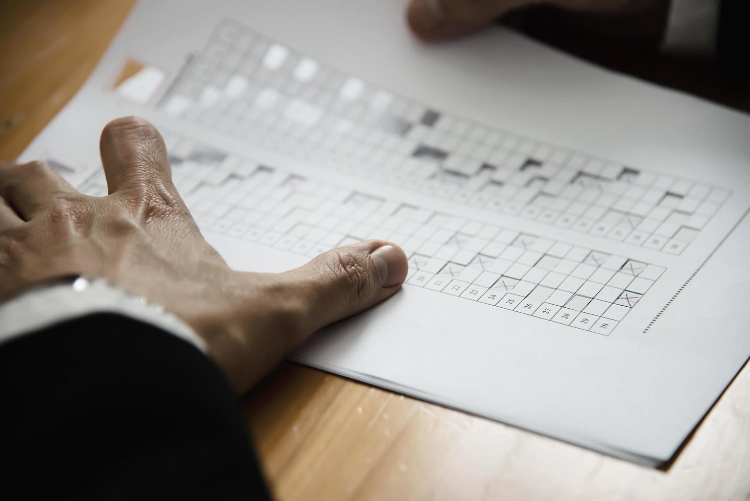 Instructor checking multiple choices answer sheet exam - education people working with paper test concept photo