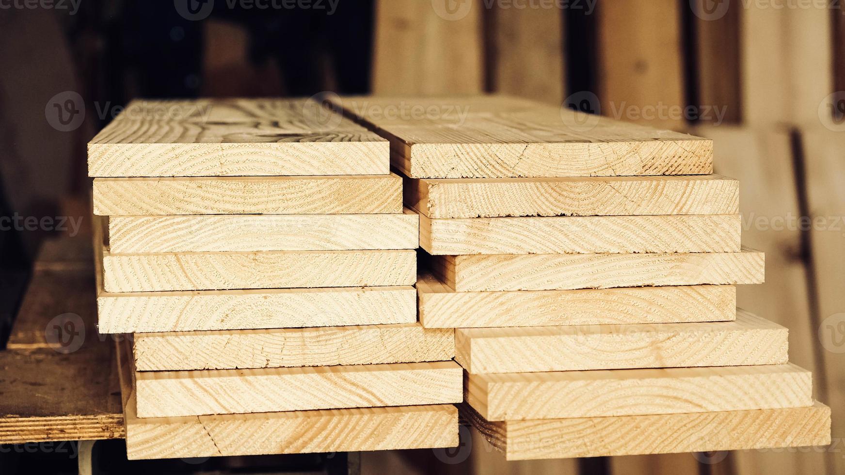 Stacked wooden carpentry boards from natural wood in a woodworking industry photo