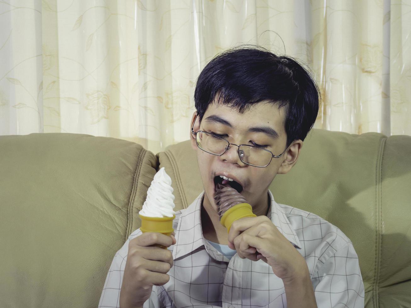 niño de asia niño sostenga helado de vainilla en cono de gofres feliz sonriendo y comiendo deliciosamente en verano con diversión y buen humor. foto