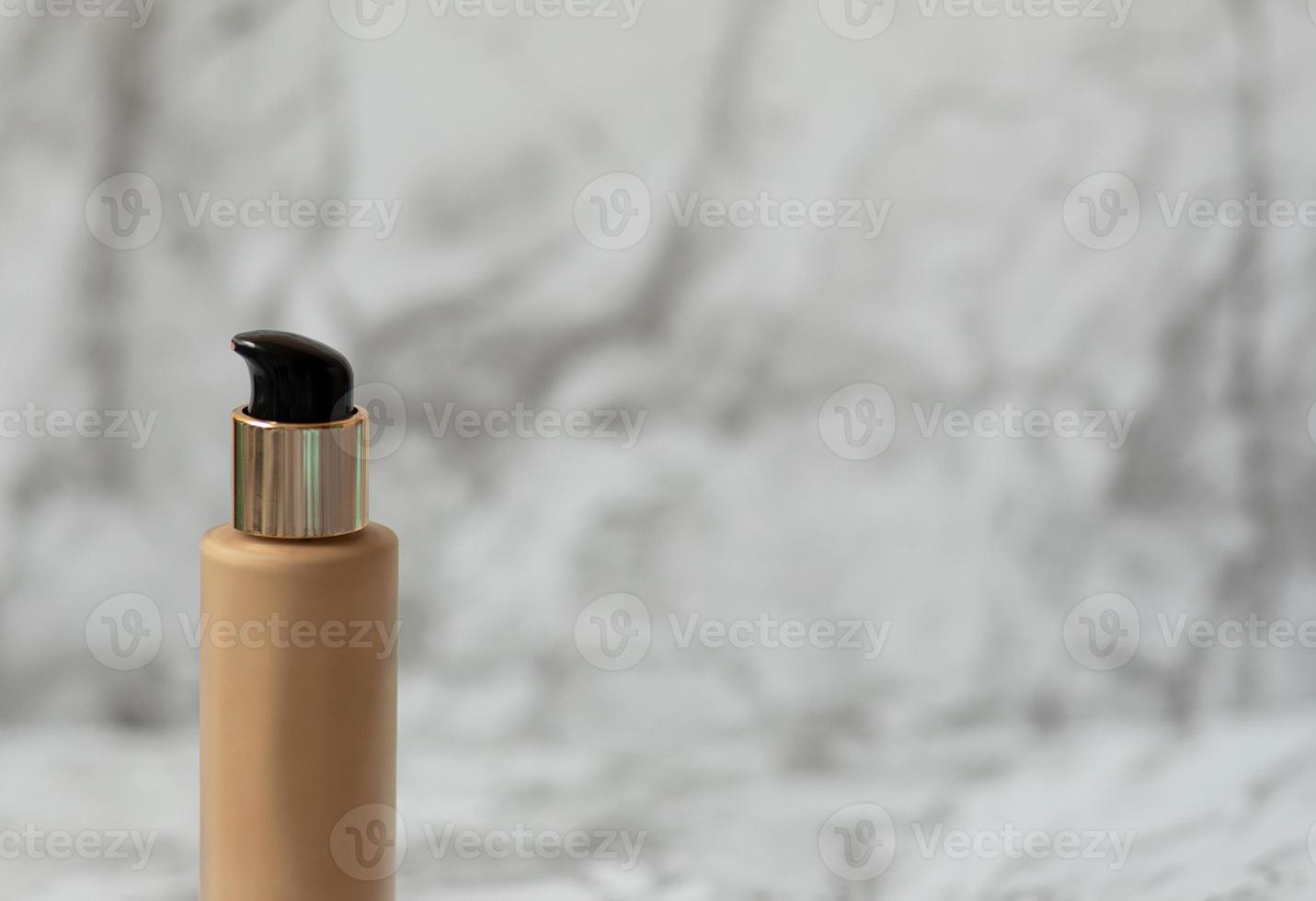 Beige foundation cream for the face on a light background photo