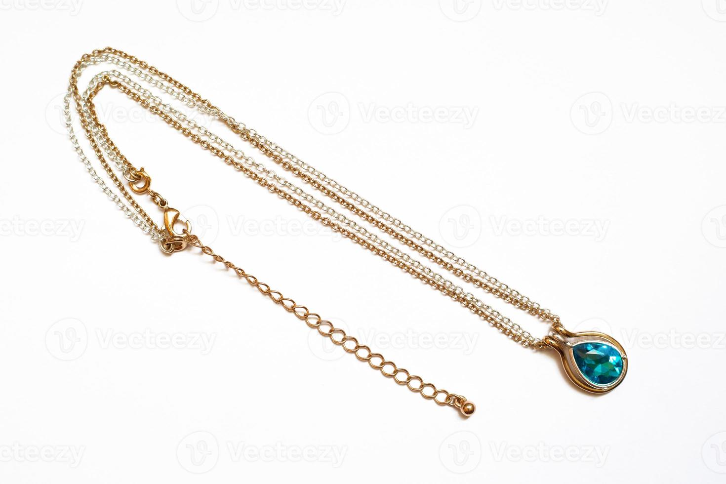 Silver gold necklace with a blue stone on a white background photo